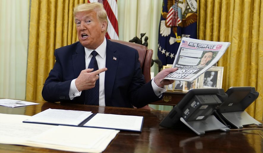 President Donald Trump holds up a copy of the New York Post as speaks before signing an executive order aimed at curbing protections for social media giants, in the Oval Office of the White House, Thursday, May 28, 2020, in Washington. (AP Photo/Evan Vucci)