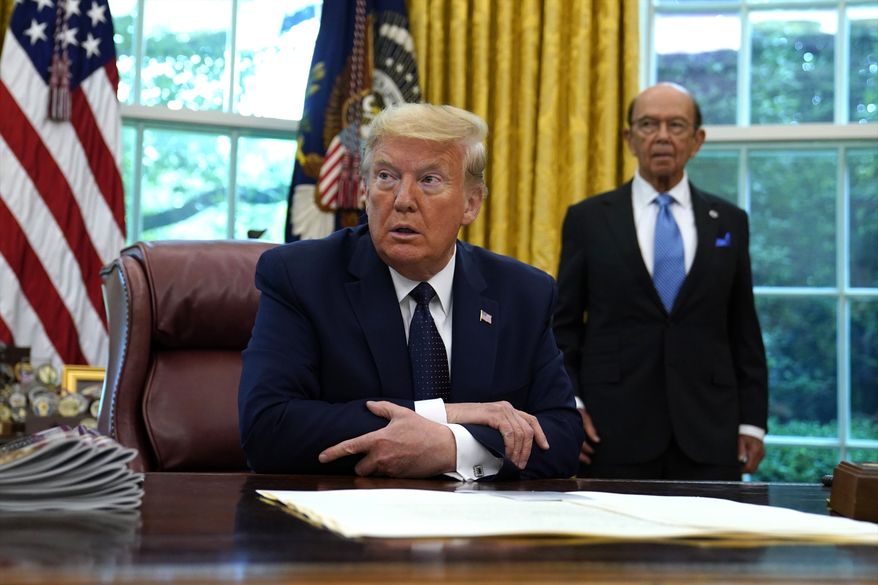 President Donald Trump listens as he receives a briefing on the 2020 hurricane season in the Oval Office of the White House, Thursday, May 28, 2020, in Washington. Commerce Secretary Wilbur Ross listens at right. (AP Photo/Evan Vucci)