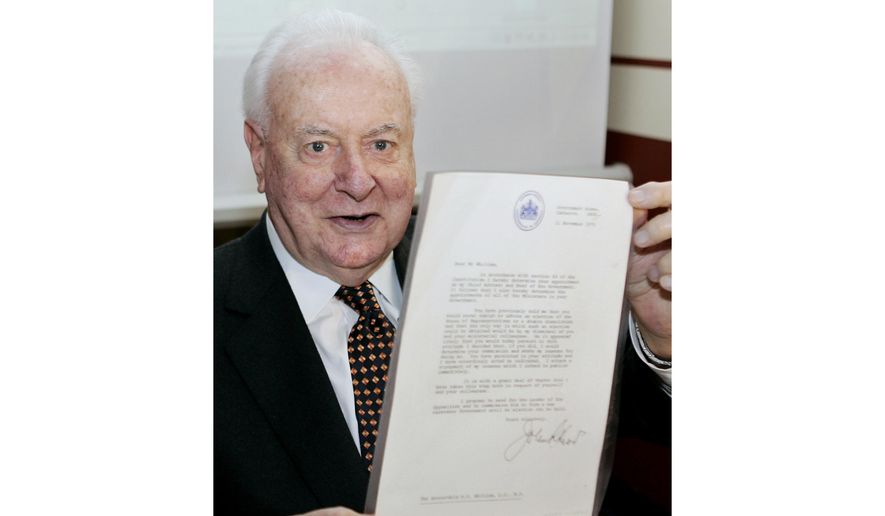 In this Nov. 7, 2005, file photo, former Australian Prime Minister Gough Whitlam holds up the original copy of his dismissal letter he received from then Governor-General Sir John Kerr on Nov. 11, 1975, at a book launch in Sydney, Australia. The High Court&#39;s majority decision in historian Jenny Hocking’s appeal on Friday, May 29, 2020, overturned lower court rulings that more than 200 letters between the monarch of Britain and Australia and Governor-General Sir John Kerr before he dismissed Prime Minister Gough Whitlam’s government were personal and might never be made public. (AP Photo/Mark Baker, File)
