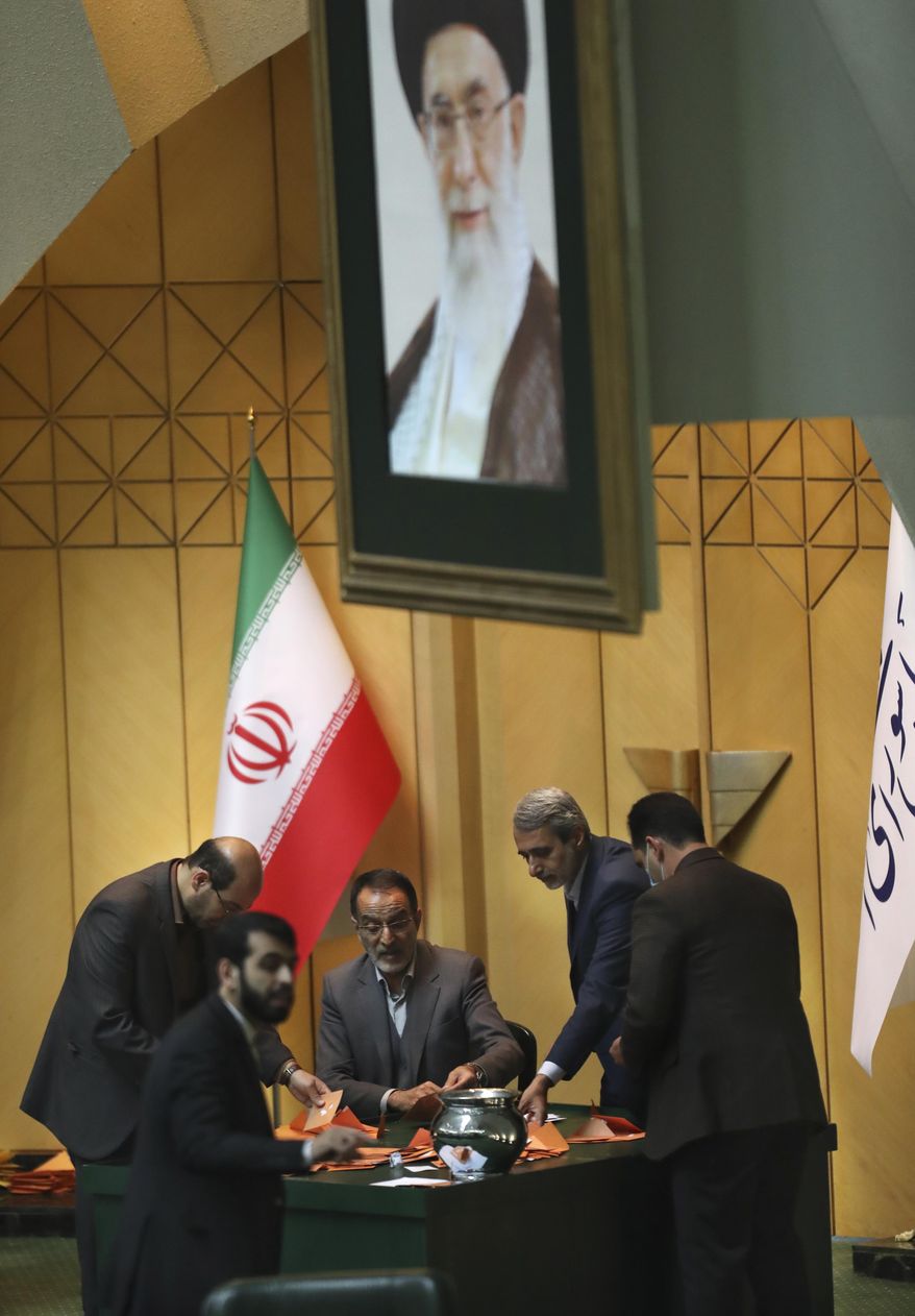 Under a portrait of the Supreme Leader Ayatollah Ali Khamenei, a group of lawmakers count votes of their colleagues to elect the presiding board of the parliament in Tehran, Iran, Thursday, May 28, 2020. Iran's parliament elected Mohammad Bagher Qalibaf, a former mayor of Tehran tied to the Revolutionary Guard, as its next speaker Thursday, solidifying hard-line control of the body as tensions between the U.S. and the Islamic Republic remain high over its collapsed nuclear deal. (AP Photo/Vahid Salemi)