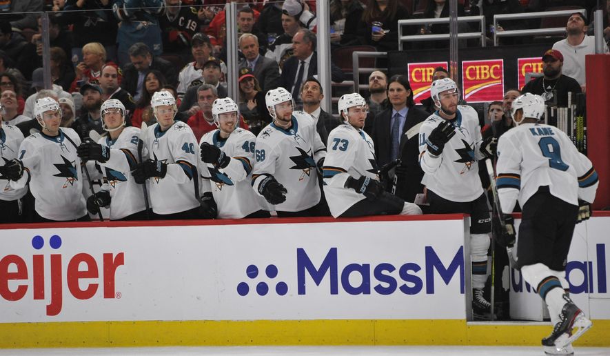 FILE - In this March 11, 2020, file photo, San Jose Sharks&#x27; Evander Kane (9) celebrates with teammates on the bench after scoring a goal during the first period of an NHL hockey game against the Chicago Blackhawks in Chicago. The Sharks had started planning for next season long before the news became official that they would be one of the seven teams left home if the NHL resumes its season. (AP Photo/Paul Beaty, File)