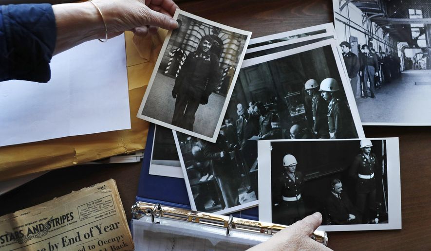 Emily DiPalma Aho looks over photographs and memorabilia of her father, Emilio DiPalma, a World War II veteran, at her home in Jaffrey, N.H., Wednesday, May 13, 2020. Emilio, who as a 19-year-old U.S. Army infantryman stood guard at the Nuremberg Nazi war crimes trials, died last month at the age of 93 after contracting the coronavirus at Holyoke Soldiers&#39; Home in Massachusetts. (AP Photo/Charles Krupa)