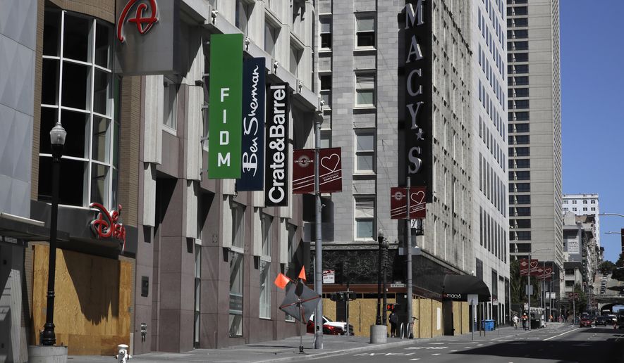 FILE - In this May 27, 2020, file photo, closed businesses are seen in downtown San Francisco. San Francisco will allow outdoor dining and indoor shopping, religious services and even sporting events without spectators June 15 with barbershops and hair salons to open for service in mid July, the city's mayor announced Thursday, May 28, 2020. (AP Photo/Ben Margot, File)