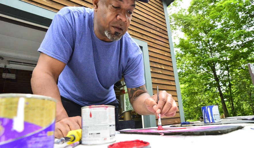 Bill Forchion, of Brattleboro, Vt., paints hearts onto slate and gives them out for free to people in the community in hopes of raising their spirits Thursday, May 28, 2020, during the COVID-19 pandemic. (Kristopher Radder/The Brattleboro Reformer via AP)