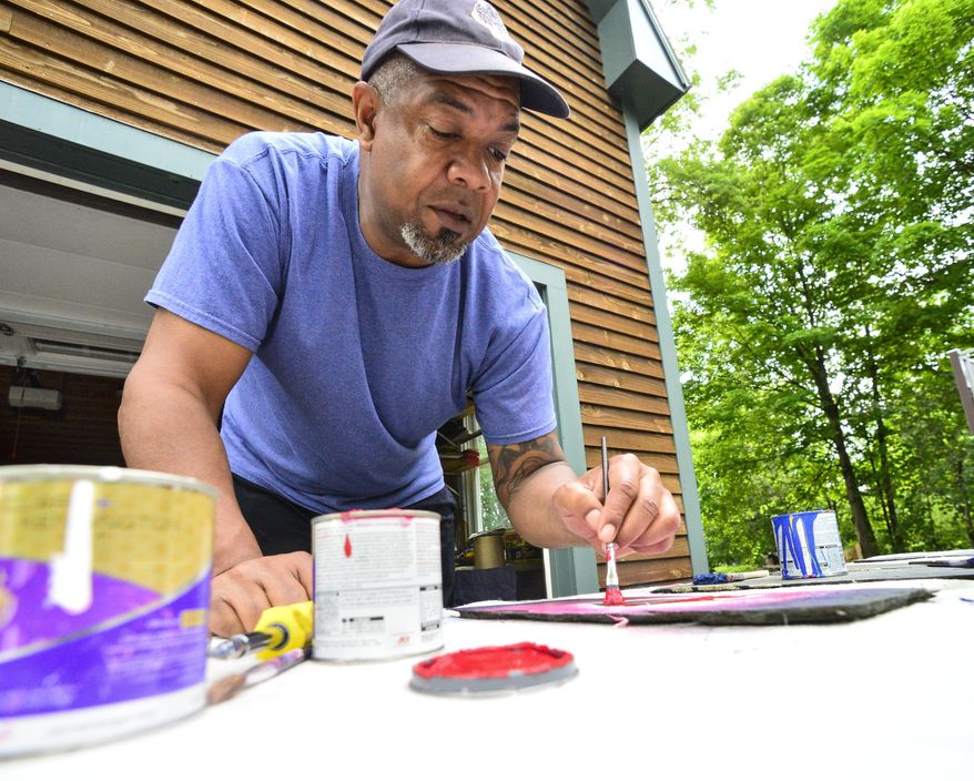Bill Forchion, of Brattleboro, Vt., paints hearts onto slate and gives them out for free to people in the community in hopes of raising their spirits Thursday, May 28, 2020, during the COVID-19 pandemic. (Kristopher Radder/The Brattleboro Reformer via AP)