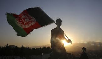 In this Aug. 19, 2019, photo, a man waves an Afghan national flag during Independence Day celebrations in Kabul, Afghanistan. Taliban fighters attacked an army checkpoint in eastern Afghanistan, killing 14 military personnel, the Defense Ministry said Friday, May 29, 2020. (AP Photo/Rafiq Maqbool) **FILE**