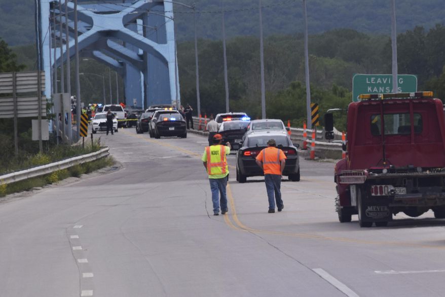 Authorities gather on Centennial Bridge after a shooting Wednesday, May 27, 2020, near Leavenworth, Kan. A Fort Leavenworth soldier is being credited with saving lives after he stopped a person who was randomly shooting on the bridge that connects Kansas and Missouri. (John Richmeier/Leavenworth Times via AP)