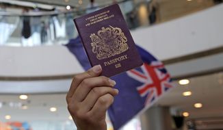 Protesters hold a British National (Overseas) passport and Hong Kong colonial flag in a shopping mall during a protest against China&#39;s national security legislation for the city, in Hong Kong, Friday, May 29, 2020. The British government says t it will grant hundreds of thousands of Hong Kong residents greater visa rights if China doesn&#39;t scrap a planned new security law for the semi-autonomous territory. U.K. Foreign Secretary Dominic Raab said about 300,000 people in Hong Kong who hold British National (Overseas) passports will be able to stay in Britain for 12 months rather than the current six. (AP Photo/Kin Cheung)