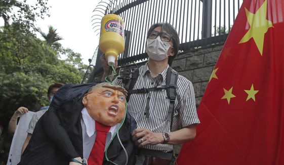 Pro-China supporters hold the effigy of U.S. President Donald Trump and Chinese national flag outside the U.S. Consulate during a protest in Hong Kong, Saturday, May 30, 2020. President Donald Trump has announced a series of measures aimed at China as a rift between the two countries grows. He said Friday that he would withdraw funding from the World Health Organization, end Hong Kong&#x27;s special trade status and suspend visas of Chinese graduate students suspected of conducting research on behalf of their government. (AP Photo/Kin Cheung) **FILE**