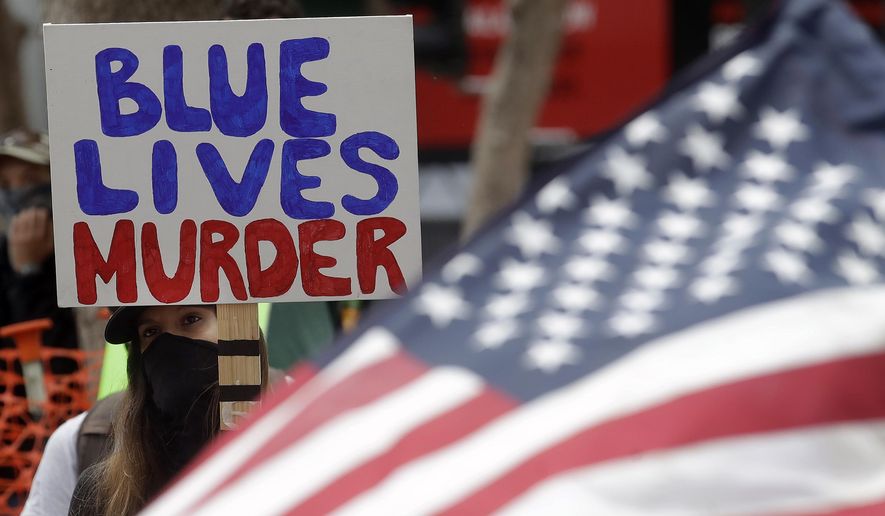 A woman holds a sign at a protest over the Memorial Day death of George Floyd, a handcuffed black man in police custody in Minneapolis, in San Francisco, Saturday, May 30, 2020. (AP Photo/Jeff Chiu)
