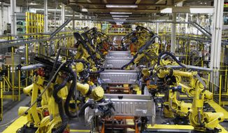 In this Sept. 27, 2018 file photo, robots weld the bed of a 2018 Ford F-150 truck on the assembly line at the Ford Rouge assembly plant in Dearborn, Mich. The U.S. auto industry’s coronavirus comeback plan was pretty simple: restart factories gradually and push out trucks and other vehicles for waiting buyers in states left largely untouched by the virus outbreak.Yet the return from a two-month production shutdown hasn’t gone quite according to plan.  (AP Photo/Carlos Osorio, File)