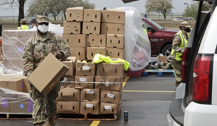 This Thursday, May 14, 2020 photo shows Specialist Scott Eubanks puts a box of food in the car at the Greater Cleveland Food Bank food distribution, in Cleveland. The Ohio Army and Air Guard saw its mission expand several times in the past three months. It now has three primary coronavirus missions: food distribution, security staffing and medical help in prisons, and collection of personal protective equipment. On Monday it adds a fourth: spreading out across the state to expand testing in nursing homes to all staff. (AP Photo/Tony Dejak)