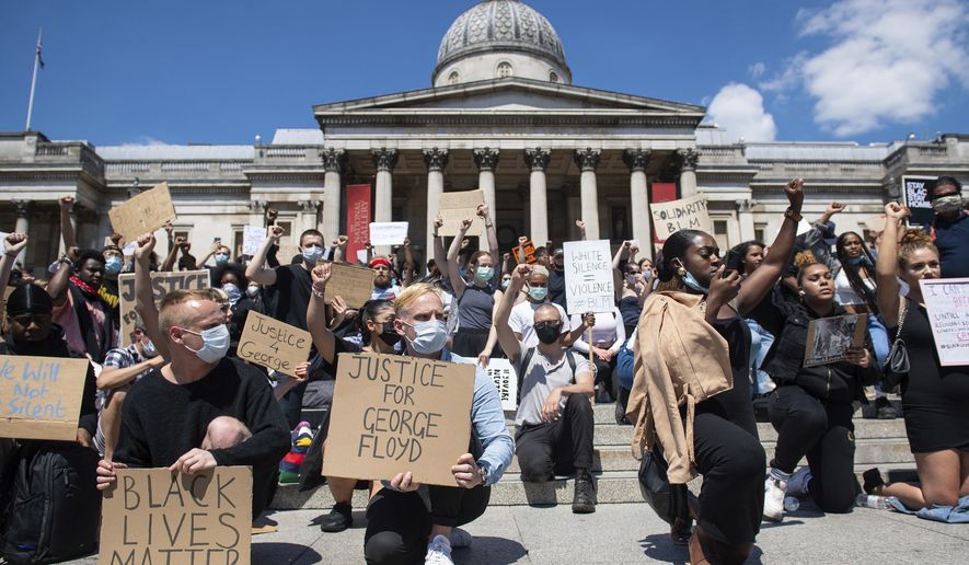 People take part in a Black Lives Matter protest in Trafalgar Square in London Sunday, May 31, 2020, to protest against the recent killing of George Floyd by police officers in Minneapolis, USA, that has led to protests in many countries and across the US.  A US police officer has been charged with the death of George Floyd. (Dominic Lipinski/PA via AP)