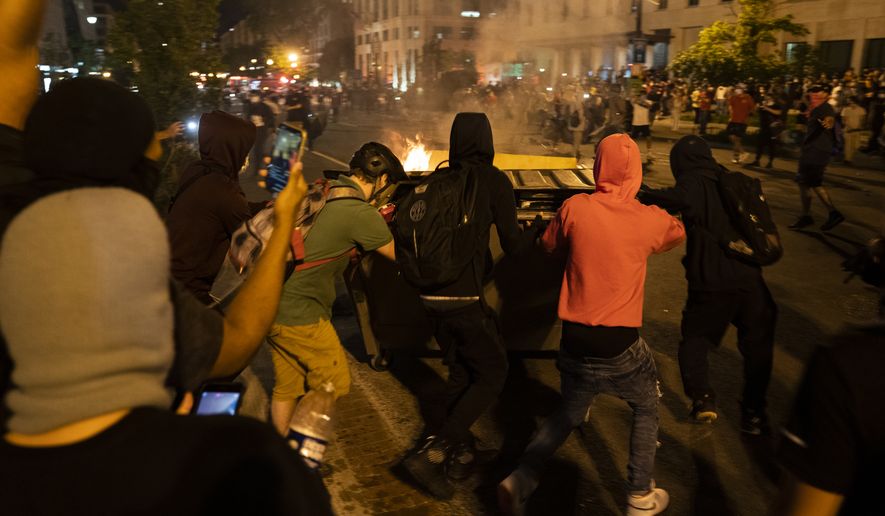 Demonstrators push a burning dumpster toward police during a protest over the death of George Floyd, Saturday, May 30, 2020, near the White House in Washington. Floyd died after being restrained by Minneapolis police officers. &#39;(AP Photo/Evan Vucci)