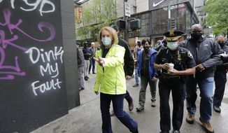 Seattle Mayor Jenny Durkan, left, surveys downtown Seattle with Police Chief Carmen Best on Sunday, May 31, 2020, following protests the night before over the death of George Floyd, a black man who was in police custody in Minneapolis. On Sunday morning, hundreds of people of all ages turned out in downtown Seattle to help clean up the damage, sweeping up broken glass and cleaning off graffiti. (AP Photo/Elaine Thompson)