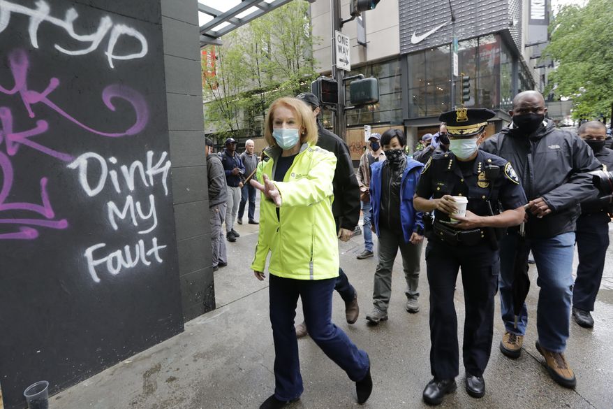 Seattle Mayor Jenny Durkan, left, surveys downtown Seattle with Police Chief Carmen Best on Sunday, May 31, 2020, following protests the night before over the death of George Floyd, a black man who was in police custody in Minneapolis. On Sunday morning, hundreds of people of all ages turned out in downtown Seattle to help clean up the damage, sweeping up broken glass and cleaning off graffiti. (AP Photo/Elaine Thompson)