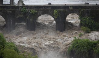 The swollen Los Esclavos River flows violently under a bridge during tropical storm Amanda in Cuilapa, eastern Guatemala, Sunday, May 31, 2020. The first tropical storm of the Eastern Pacific season drenched parts of Central America on Sunday and officials in El Salvador said at least seven people had died in the flooding. (AP Photo/Moises Castillo)