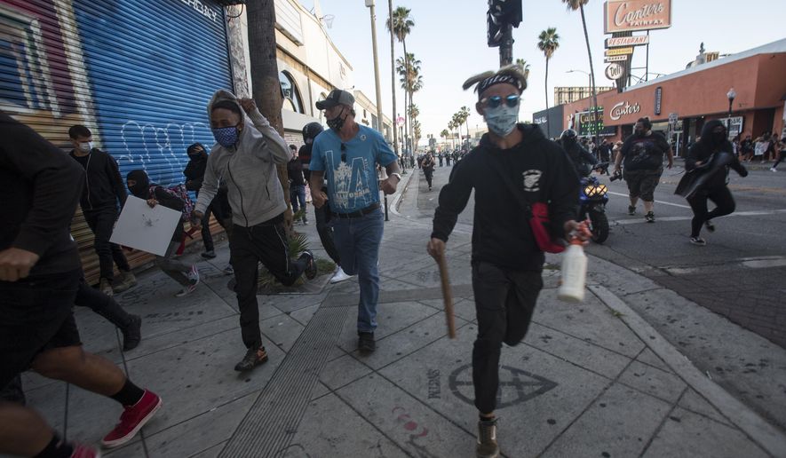 Protesters run as police officers fire rubber bullets during a protest over the death of George Floyd, a handcuffed black man in police custody in Minneapolis, in Los Angeles, Saturday, May 30, 2020. (AP Photo/Ringo H.W. Chiu)