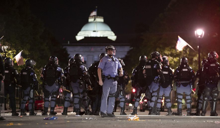 Raleigh Police block Fayetteville Street at Hargett Street as they work to return order after a night of violent demonstrations early Sunday, May 31, 2020, in Raleigh, N.C., as people nationwide protested the Memorial Day death of George Floyd, who died in police custody in Minneapolis. (Robert Willett/The News & Observer via AP)