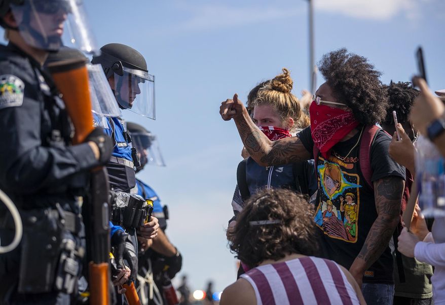 Protesters confront Austin Police officers on the southbound lane of Interstate 35, Saturday, May 30, 2020, in Austin, Texas, during demonstrations in response to the Memorial Day death of George Floyd while in police custody in Minneapolis. (Ricardo B. Brazziell/Austin American-Statesman via AP)