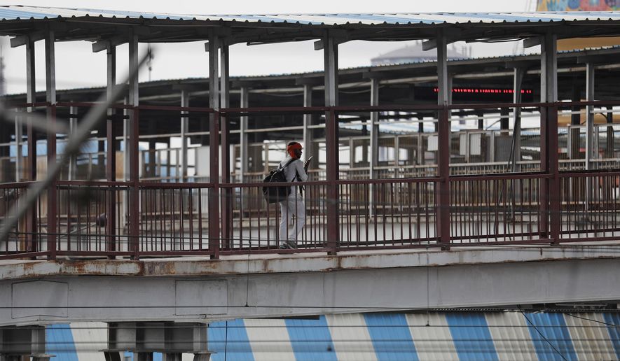 A migrant worker leaves a railway station after arriving on a train from Maharashtra state, in Prayagraj, India, Saturday, May 30, 2020. India is extending the ongoing lockdown in containment zones till June 30 but will allow all economic activities to restart in a phased manner outside these areas even though coronavirus cases continue to rise in its major cities. The upcoming reopening phase which will start Monday is called Unlock 1, the home ministry said in a directive Saturday. (AP Photo/Rajesh Kumar Singh)