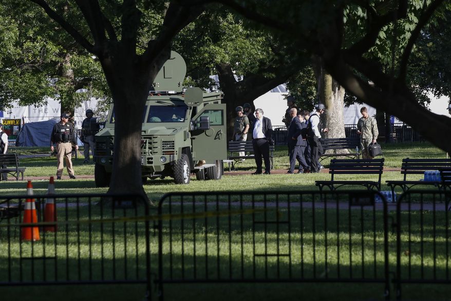 Attorney General William Barr, center, stands in Lafayette Park across from the White House as demonstrators gather to protest the death of George Floyd, Monday, June 1, 2020, in Washington. Floyd died after being restrained by Minneapolis police officers. (AP Photo/Alex Brandon)
