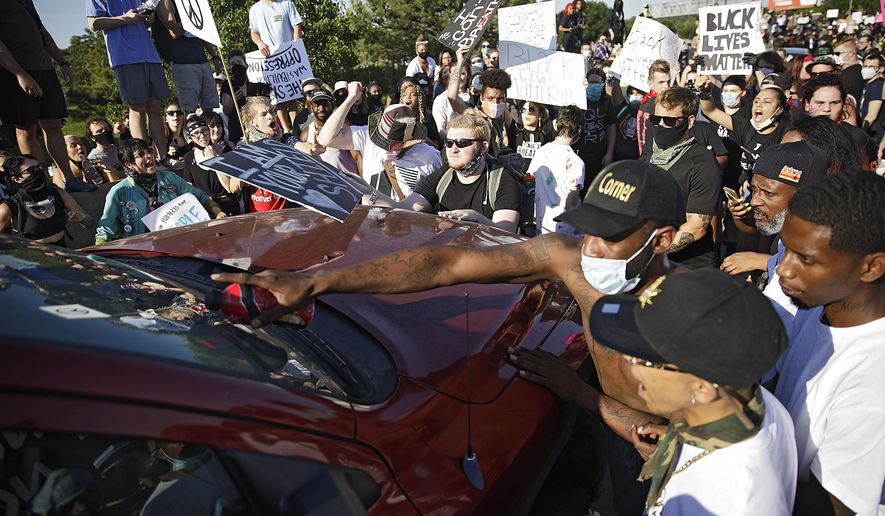 Protesters surround a truck shortly before it drove through the group injuring several on Interstate 244 in Tulsa, Okla., Sunday, May 31, 2020. The group was protesting the killing of George Floyd by Minneapolis police on May 25 and commemorating the 1921 Tulsa Race Massacre. (Mike Simons/Tulsa World via AP)