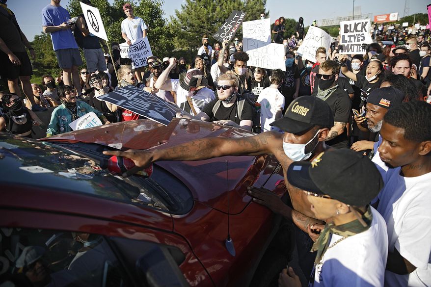 Protesters surround a truck shortly before it drove through the group injuring several on Interstate 244 in Tulsa, Okla., Sunday, May 31, 2020. The group was protesting the killing of George Floyd by Minneapolis police on May 25 and commemorating the 1921 Tulsa Race Massacre. (Mike Simons/Tulsa World via AP)