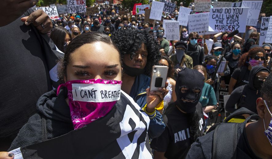 A young woman with the words &amp;quot;I can&#39;t breathe&amp;quot; on her face covering joins thousands at a Black Lives Matter event in Eugene, Ore., Sunday May 31, 2020, over the deaths of George Floyd and others (Chris Pietsch/The Register-Guard via AP)