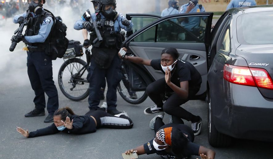 Motorists are ordered to the ground from their vehicle by police during a protest on South Washington Street, Sunday, May 31, 2020, in Minneapolis. Protests continued following the death of George Floyd, who died after being restrained by Minneapolis police officers on Memorial Day. (AP Photo/John Minchillo)