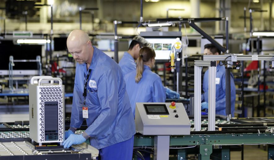 FILE - In this Nov. 20, 2019, file photo, workers are shown at an Apple manufacturing plant in Austin, Texas. American factories slowed for the third consecutive month in May as they continued to sustain economic damage from the coronavirus pandemic. The Institute for Supply Management, an association of purchasing managers, said Monday, June 1, 2020, that its manufacturing index came in at 43.1 last month after registering 41.5 in April. Anything below 50 signals that U.S. manufacturers are in retreat. (AP Photo/ Evan Vucci, File)