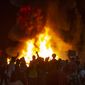 In this May 29, 2020, photo, protesters light a fire to block West 7th Ave. at Jefferson St. in Eugene, Ore. during a protest over the killing of George Floyd in Minneapolis, Minnesota. (Chris Pietsch/The Register-Guard via AP)