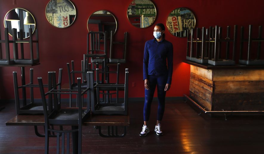 In this Thursday, May 21, 2020, image, Stephanie Byrd, co-owner of The Block, poses for a photo with chairs on the tables while the restaurant is closed due to the coronavirus in Detroit. She’s worried other black-owned businesses will struggle to withstand another wave of economic uncertainty during the pandemic, following decades of inequity that made it hard for many to flourish in the first place. (AP Photo/Paul Sancya)