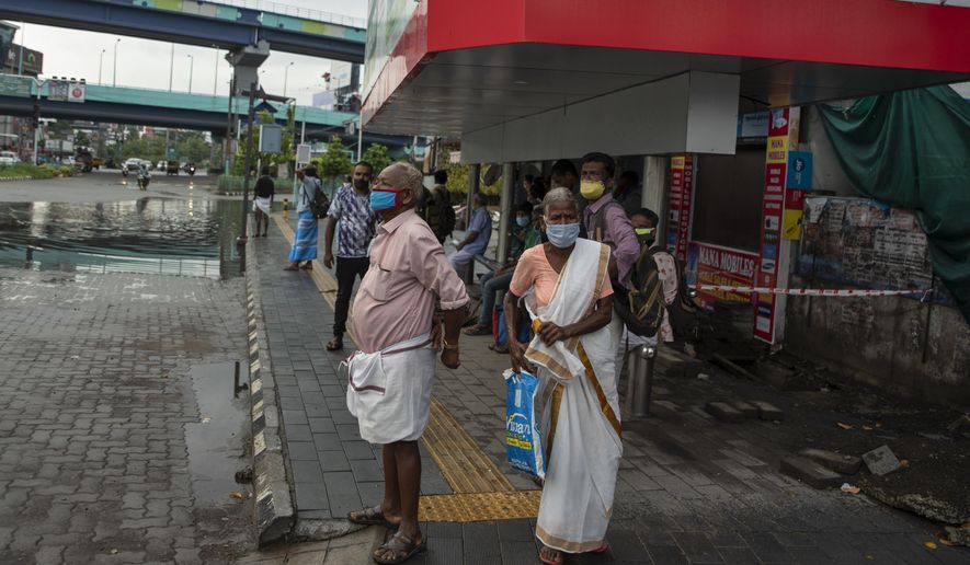 People wearing face masks to protect from the new coronavirus as they wait for bus transport in Kochi, Kerala state, India, Monday, June 1, 2020. More states opened up and crowds of commuters trickled on the roads in many cities as India&#39;s three-phase plan to lift the virus lockdown kick started Monday amidst an upward trend in new infections and fatalities due to COVID-19. (AP Photo/ R S Iyer)