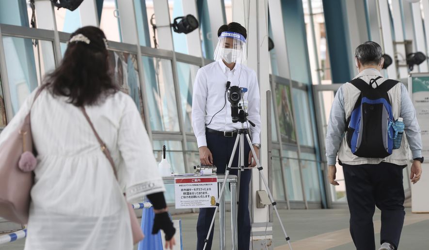 Visitors walk past a thermography camera monitors as the Hakkeijima Sea Paradise amusement park opens after a two-month closure due to the preventative measures to help curb the spread of the coronavirus in Yokohama near Tokyo, Monday, June 1, 2020. (AP Photo/Koji Sasahara)