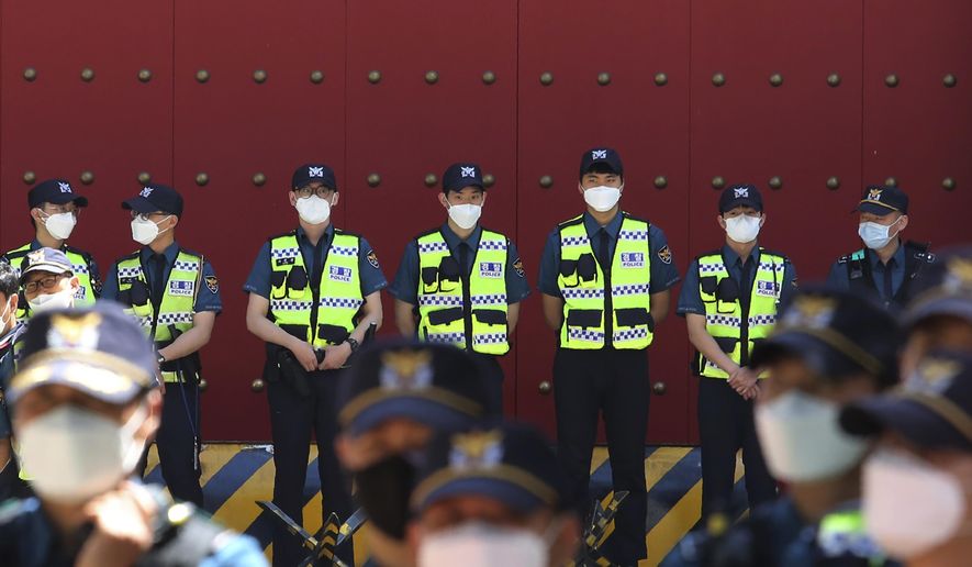 Police officers wearing face masks to help protect against the spread of the new coronavirus stand guard in front of the Chinese embassy in Seoul, South Korea, Monday, June 1, 2020. (AP Photo/Ahn Young-joon)