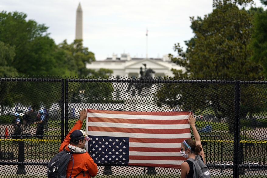 Demonstrators protest the death of George Floyd with an upside-down American flag, Tuesday, June 2, 2020, near the White House in Washington. Floyd died after being restrained by Minneapolis police officers. (AP Photo/Evan Vucci)