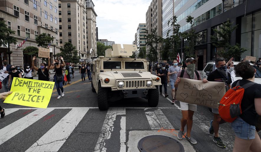 Demonstrators march past a military humvee as they protest the death of George Floyd, Tuesday, June 2, 2020, in Washington. Floyd died after being restrained by Minneapolis police officers. (AP Photo/Alex Brandon)
