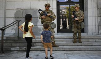 Bianca Luna, 6, left, and Elijah Ducey, 3, ask members of the California National Guard if they would like some water, as they stand guard at the Stanley Mosk Library and Courts Building in Sacramento, Calif., Tuesday, June 2, 2020. More than 2,400 members are deployed in several cities to guard infrastructure, freeing up law enforcement officers to respond to incidents like vandalism and looting that occurred during demonstrations sparked by the death of George Floyd, who died after being restrained by Minneapolis police officers on May 25. (AP Photo/Rich Pedroncelli)