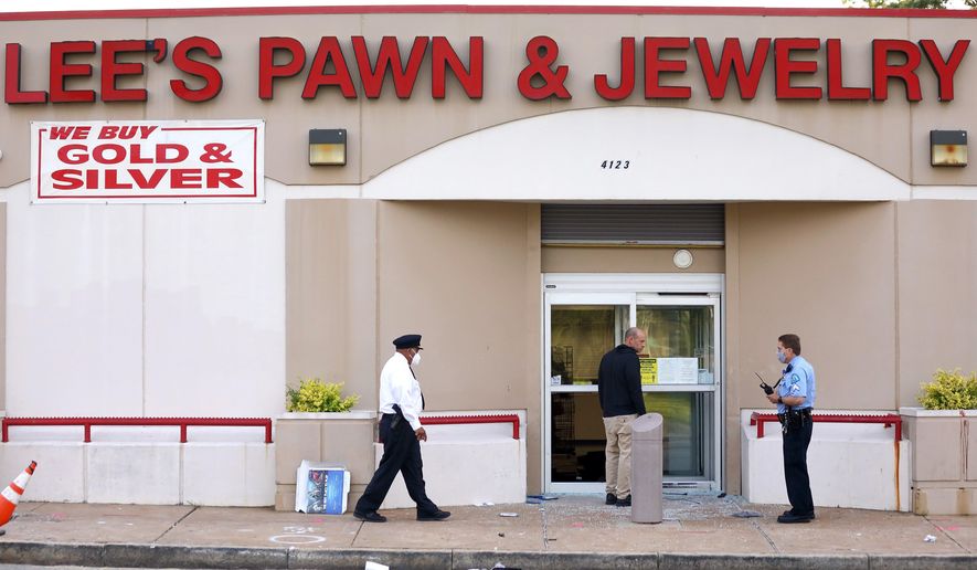 Police investigate the scene of a shooting at Lee&#39;s Pawn &amp;amp; Jewelry in St. Louis, Tuesday, June 2, 2020. A 77-year-old retired St. Louis police officer who served 38 years on the force was shot and killed by looters at the pawn shop early Tuesday, police said. David Dorn was found dead on the sidewalk in front of Lee&#39;s Pawn &amp;amp; Jewelry, which had been ransacked after peaceful protests over the death of George Floyd turned violent overnight. (David Carson/St. Louis Post-Dispatch via AP)