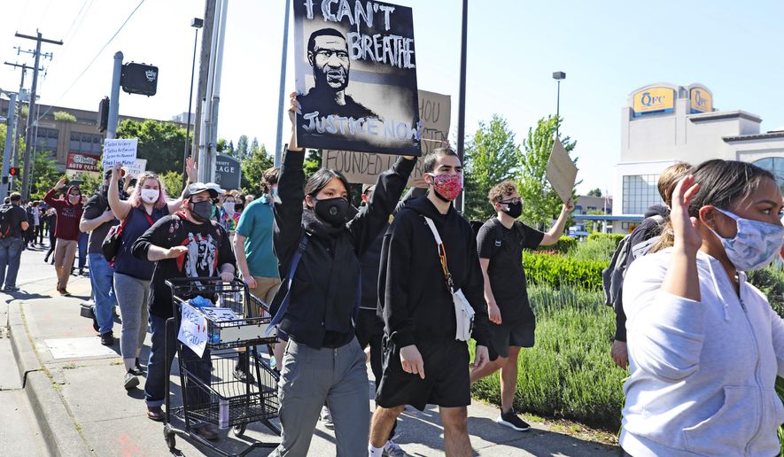 People peacefully protest at University Village, Monday, June 1, 2020, in Seattle as demonstrations continued, sparked by the death of George Floyd in Minneapolis. (Ken Lambert/The Seattle Times via AP)