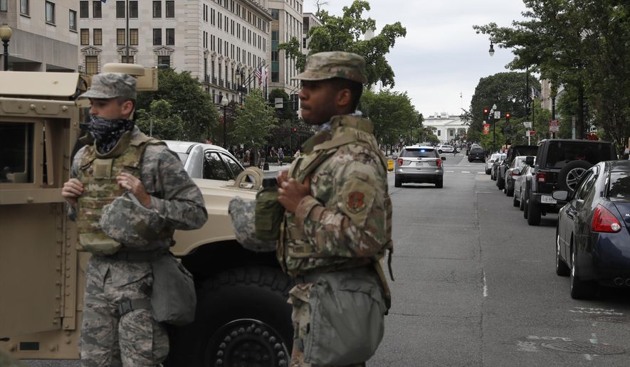 Members of the D.C. National Guard block an intersection on 16th Street as demonstrators gather to protest the death of George Floyd, Tuesday, June 2, 2020, near the White House in Washington. Floyd died after being restrained by Minneapolis police officers. (AP Photo/Jacquelyn Martin) ** FILE **