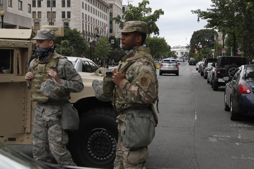 Members of the D.C. National Guard block an intersection on 16th Street as demonstrators gather to protest the death of George Floyd, Tuesday, June 2, 2020, near the White House in Washington. Floyd died after being restrained by Minneapolis police officers. (AP Photo/Jacquelyn Martin) ** FILE **