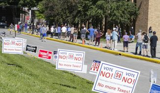 Voters wait in a line outside Broad Ripple High School to vote in the Indiana primary in Indianapolis, Tuesday, June 2, 2020 after coronavirus concerns prompted officials to delay the primary from its original May 5 date. Voters waited up to two hours to cast their ballots. Nearly 550,000 voters requested mail-in ballots, more than 10 times the number of those ballots cast during the 2016 primary. (AP Photo/Michael Conroy)