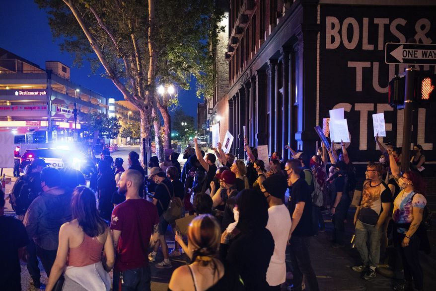 Dozens of people march from the Omaha Douglas Civic Center to the Old Market in Omaha, Neb., Wednesday, June 3, 2020. James Scurlock, a 22-year-old black man, was shot and killed in the Old Market on Saturday night by a white bar owner. (Anna Reed/Omaha World-Herald via AP)