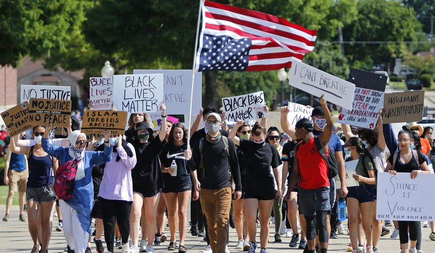 Protesters march beside the Plano Police Department at a protest organized by Our Revolution Texas, Wednesday, June 3, 2020, in Plano, Texas. (Stewart F. House/The Dallas Morning News via AP)  ** FILE ** 