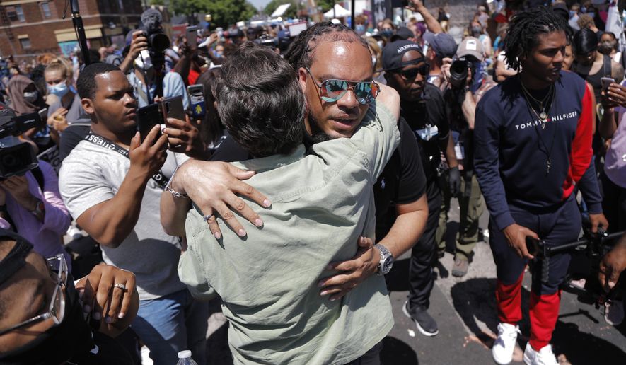 The Reverend Greg Drumwright greets people at the memorial site for Greg Floyd Wednesday, June 3, 2020, in Minneapolis. Protests continued following the death of Floyd, who died after being restrained by Minneapolis police officers on Memorial Day. (AP Photo/Julio Cortez)