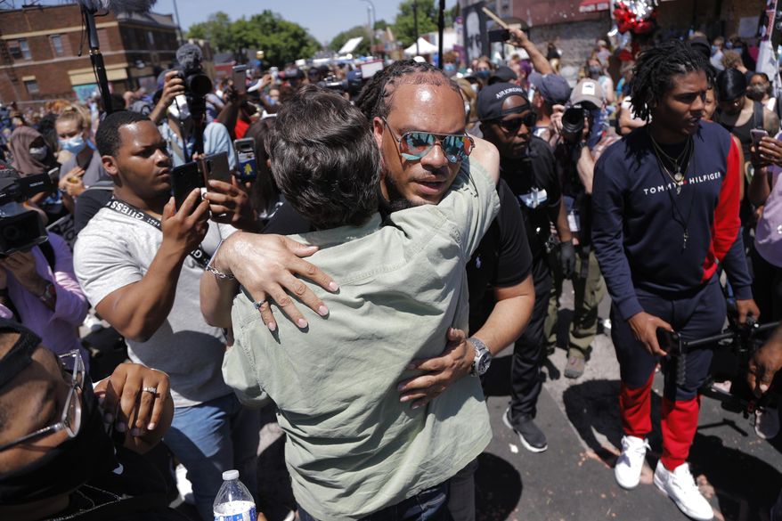 The Reverend Greg Drumwright greets people at the memorial site for Greg Floyd Wednesday, June 3, 2020, in Minneapolis. Protests continued following the death of Floyd, who died after being restrained by Minneapolis police officers on Memorial Day. (AP Photo/Julio Cortez)