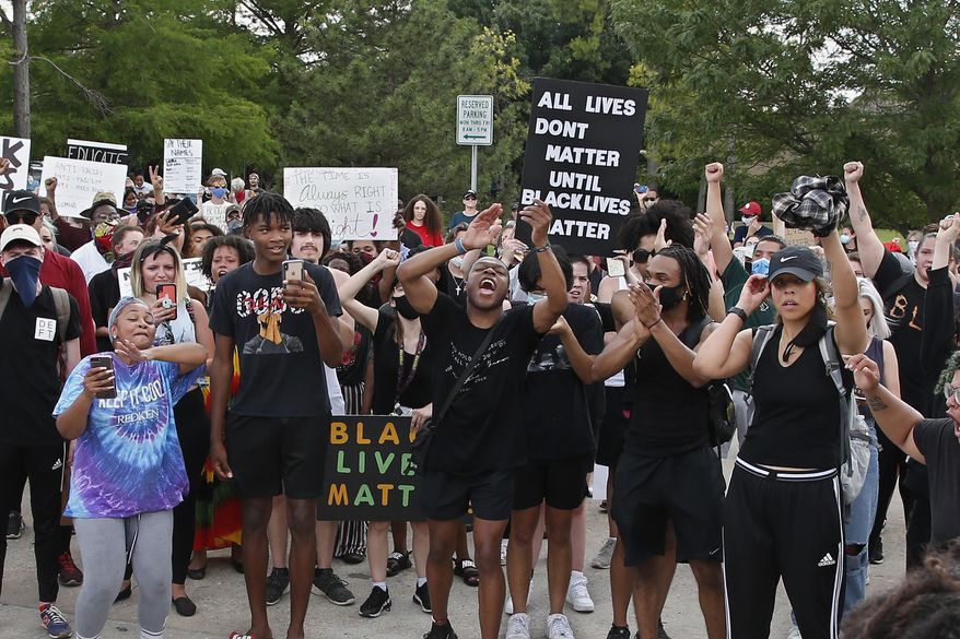 Demonstrators chant outside the Norman Police Department on Tuesday, June 2, 2020, in Norman, Okla., during a protest over the death of George Floyd, who died after being restrained by Minneapolis police officers May 25. (AP Photo/Sue Ogrocki)