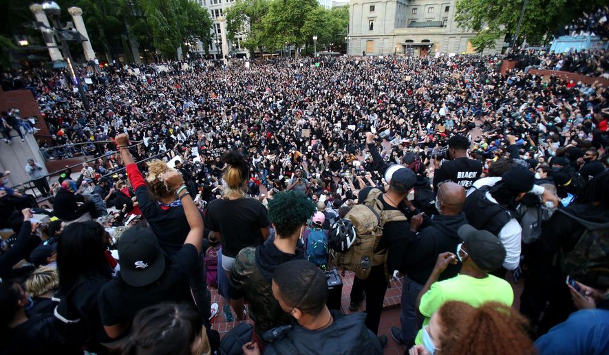 A crowd gather in Pioneer Square in downtown Portland by dusk on Tuesday, June 2, 2020 as protests continued for a sixth night in Portland, demonstrating against the death of George Floyd. Floyd died after being restrained by Minneapolis police officers on May 25.(Sean Meagher/The Oregonian via AP)